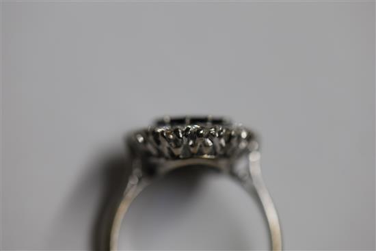 A modern white gold?, sapphire and diamond set oval cluster ring, size N.